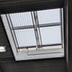 Blick von innen auf eine RWA-Lichtkuppel mit Durchsturzgitter und Öffnungsantrieb